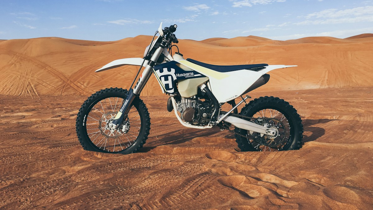 Dirt bike parked in desert sand dunes