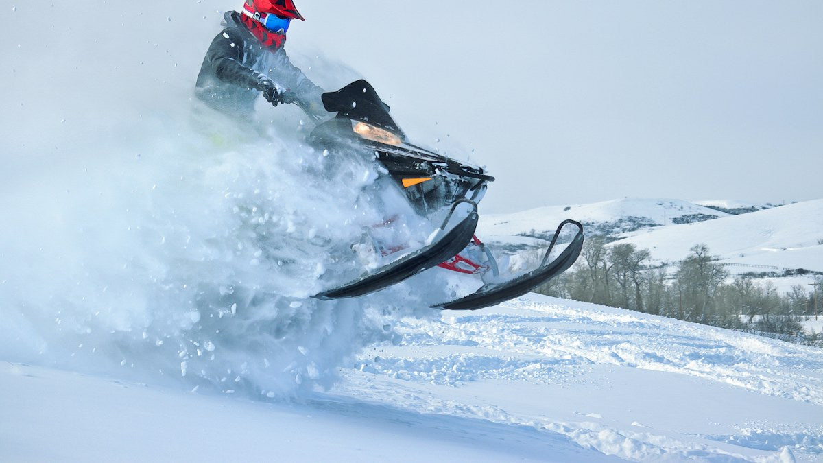Snowmobile rider blasting through powder